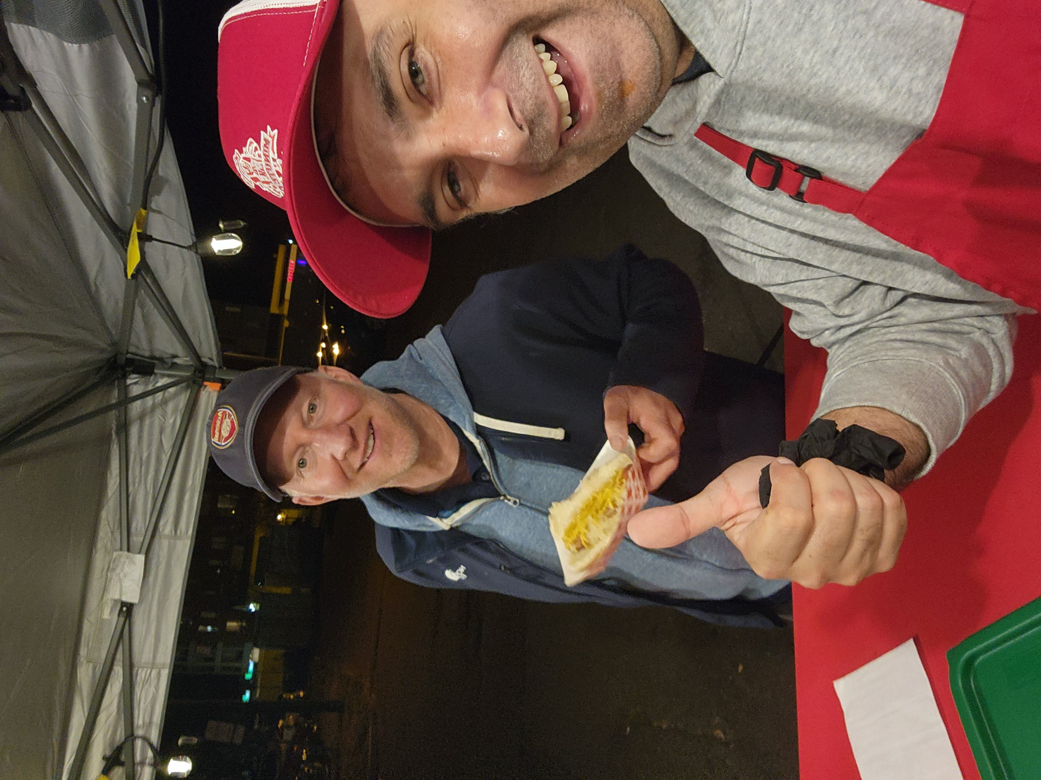 Minute Dog customer holding a finished hot dog at the cart